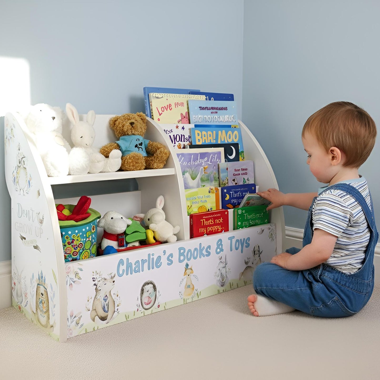 Child playing with a toy and book storage unit labeled 'Charlie's Books & Toys' in a room.
